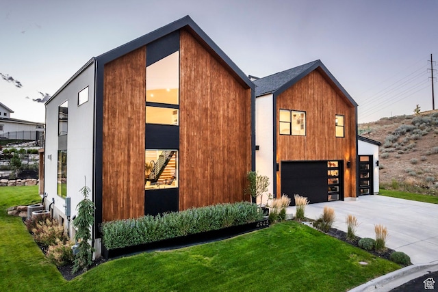 contemporary home with a garage and a lawn