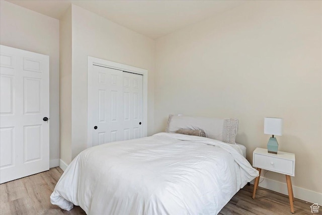 bedroom with light hardwood / wood-style flooring and a closet