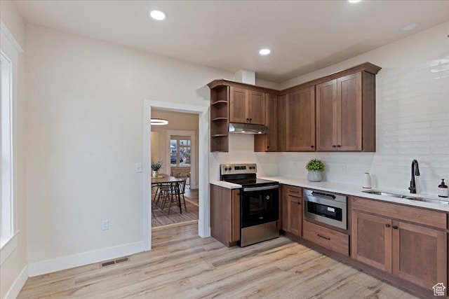 kitchen featuring backsplash, light hardwood / wood-style floors, sink, and appliances with stainless steel finishes