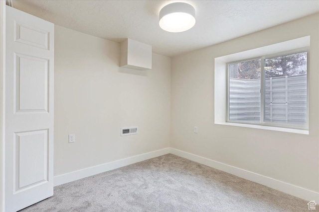 carpeted spare room with a textured ceiling