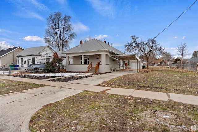 bungalow-style home with covered porch, a carport, and a garage