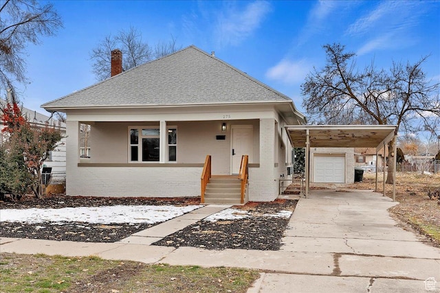 bungalow-style house featuring covered porch, a garage, and a carport