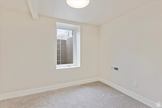 spare room with beam ceiling and carpet floors