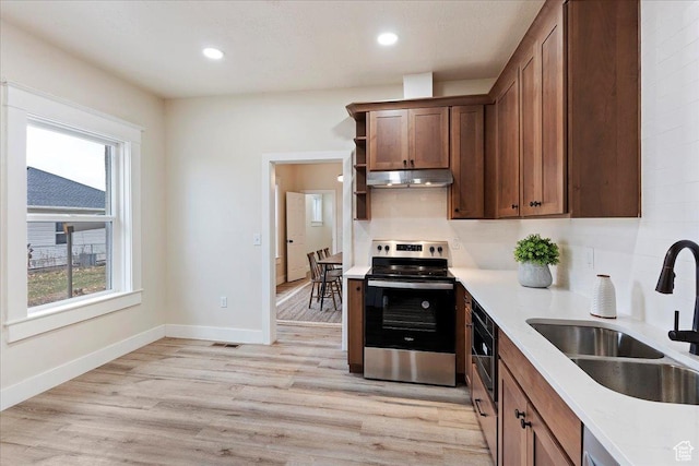 kitchen featuring electric range, tasteful backsplash, sink, and light hardwood / wood-style flooring
