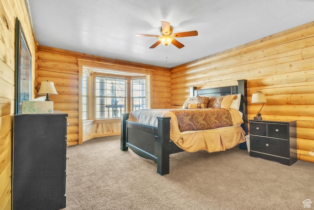 carpeted bedroom featuring rustic walls and ceiling fan