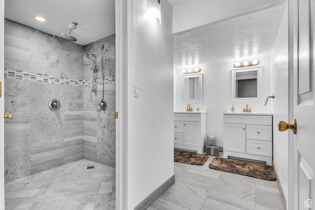bathroom with vanity and tiled shower