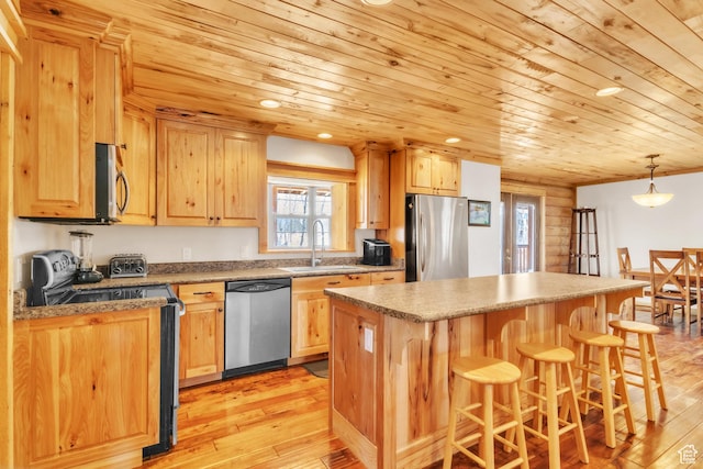 kitchen featuring sink, wooden ceiling, hanging light fixtures, a kitchen island, and appliances with stainless steel finishes