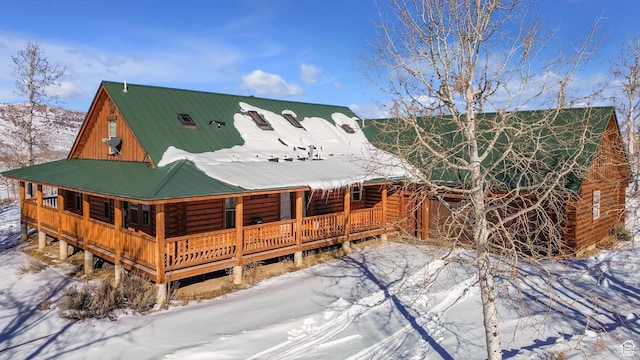 view of snow covered back of property