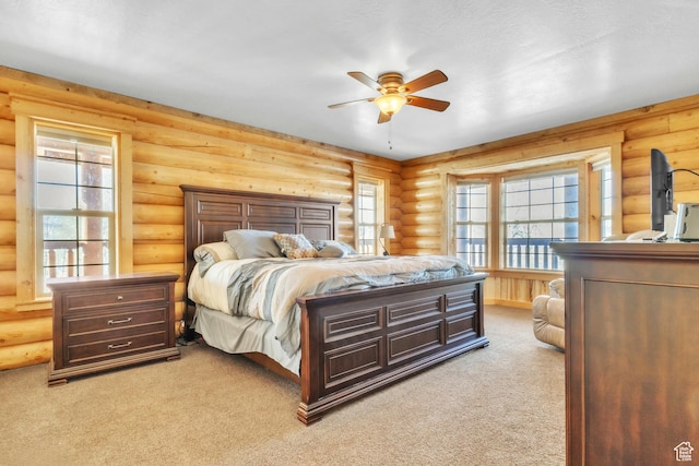 bedroom with ceiling fan, log walls, and light colored carpet