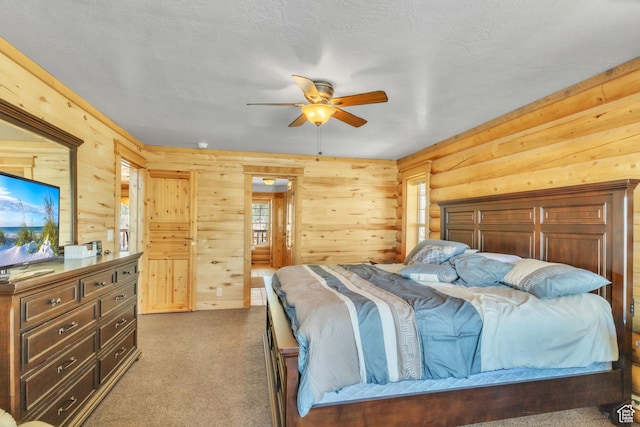 carpeted bedroom featuring a textured ceiling, ceiling fan, and wood walls