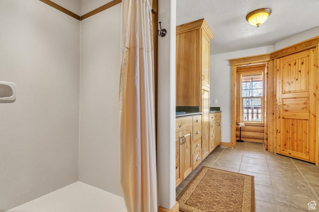 bathroom featuring tile patterned flooring, vanity, and a textured ceiling