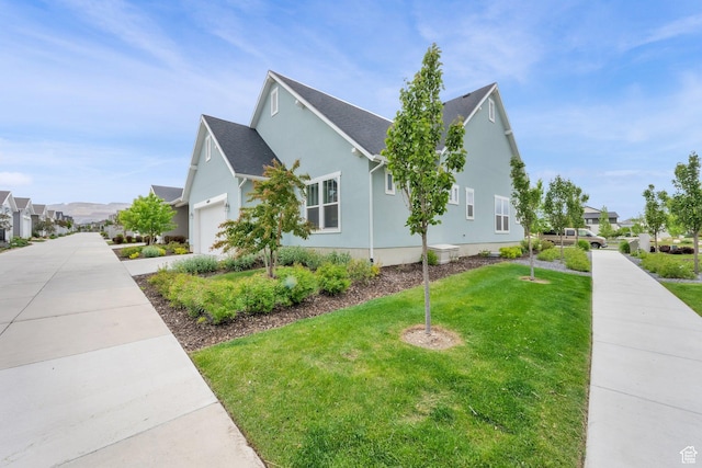 view of side of property featuring a lawn, a residential view, and stucco siding
