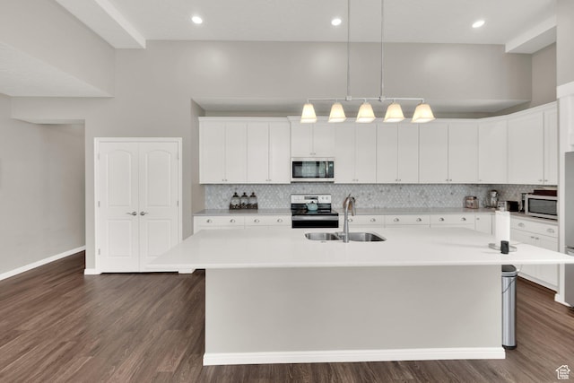 kitchen featuring appliances with stainless steel finishes, a sink, backsplash, white cabinetry, and recessed lighting