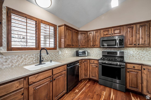 4876 S 1525 E, Ogden, UT 84403 - kitchen featuring a sink, dark wood-style floors, stainless steel appliances, light countertops, and vaulted ceiling
