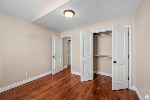 4876 S 1525 E, Ogden, UT 84403 - unfurnished bedroom featuring a closet, a textured ceiling, baseboards, and wood finished floors