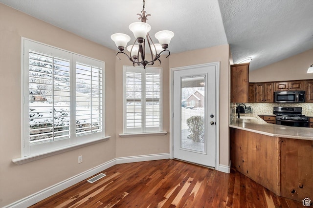 4876 S 1525 E, Ogden, UT 84403 - kitchen with visible vents, a notable chandelier, stainless steel microwave, tasteful backsplash, and black gas stove