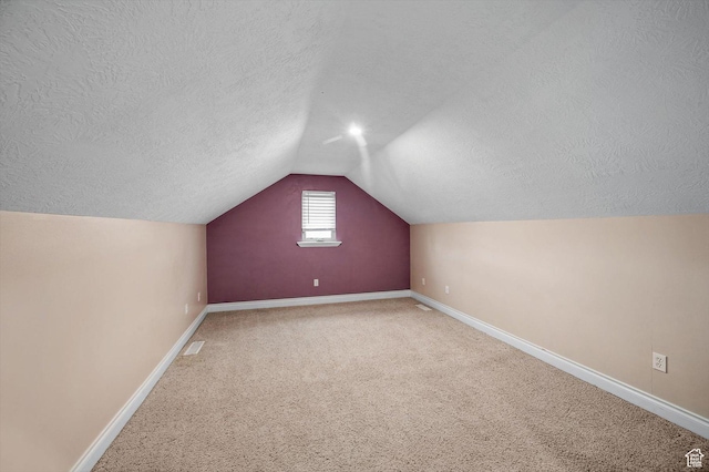 4876 S 1525 E, Ogden, UT 84403 - additional living space with visible vents, a textured ceiling, carpet, baseboards, and vaulted ceiling
