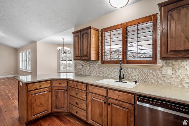 4876 S 1525 E, Ogden, UT 84403 - kitchen with dark wood-type flooring, a sink, stainless steel dishwasher, a peninsula, and an inviting chandelier