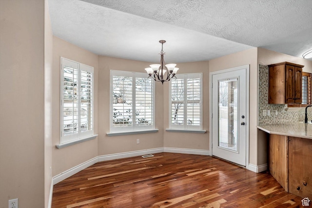 4876 S 1525 E, Ogden, UT 84403 - unfurnished dining area featuring a notable chandelier, wood finished floors, and baseboards