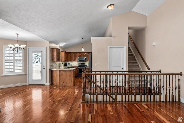 4876 S 1525 E, Ogden, UT 84403 - interior space featuring wood finished floors, baseboards, vaulted ceiling, a textured ceiling, and a notable chandelier