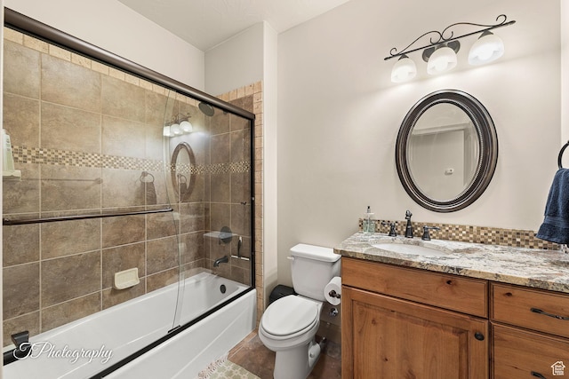 full bathroom featuring enclosed tub / shower combo, vanity, and toilet