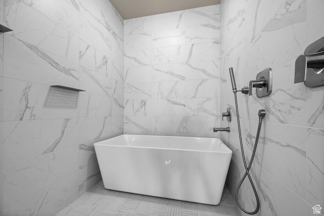 bathroom with tile walls, a shower, and a freestanding tub