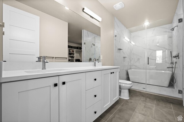 full bath featuring double vanity, a marble finish shower, toilet, and a sink