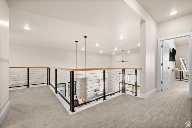 hall featuring recessed lighting, baseboards, carpet, and an upstairs landing