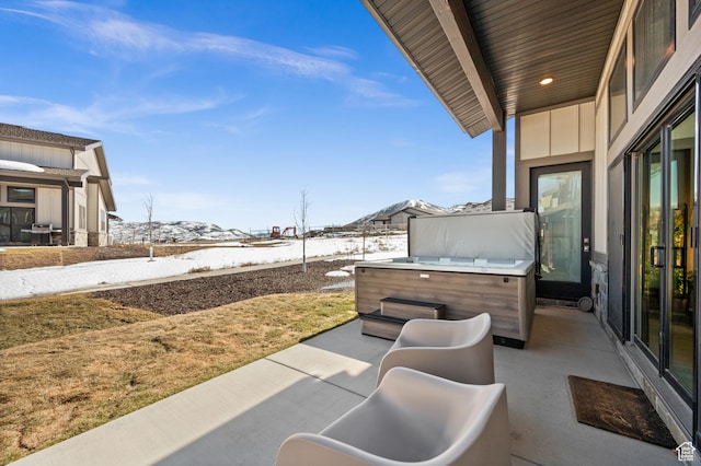 view of patio / terrace featuring a mountain view and a hot tub