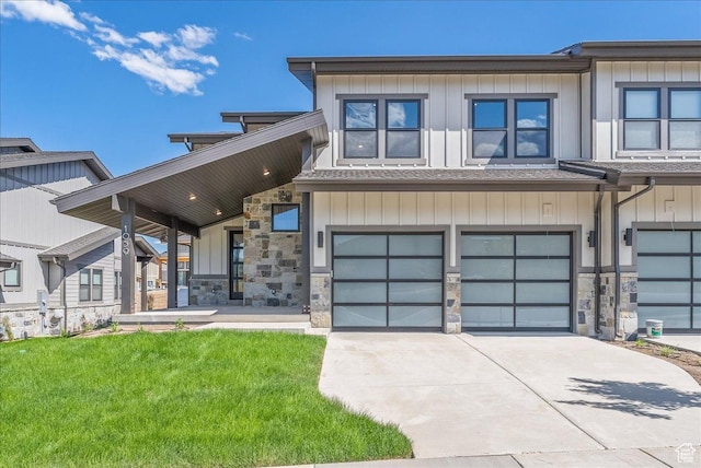 view of front facade featuring stone siding, driveway, board and batten siding, and an attached garage