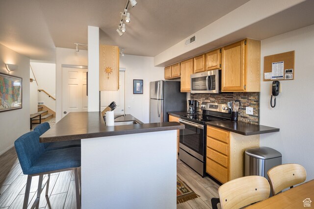 3253 E Fairway Loop, Moab, UT 84532 - kitchen with kitchen peninsula, appliances with stainless steel finishes, decorative backsplash, and sink