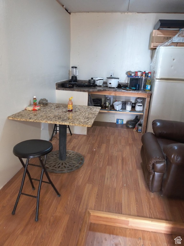 237 N 500 W, Vernal, UT 84078 - kitchen with wood finished floors, light stone counters, a kitchen bar, and freestanding refrigerator