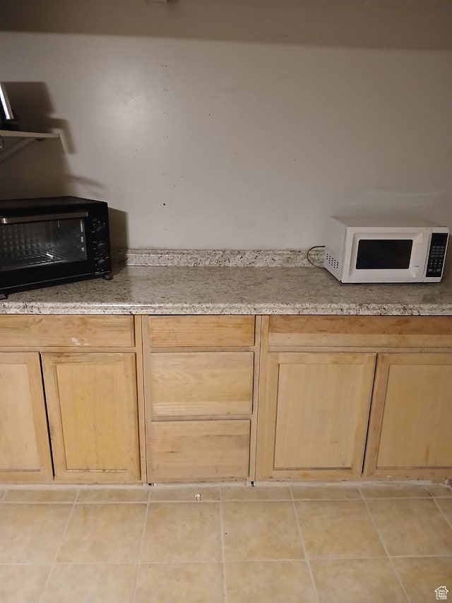 237 N 500 W, Vernal, UT 84078 - kitchen featuring white microwave, light brown cabinetry, black microwave, light tile patterned floors, and light stone countertops