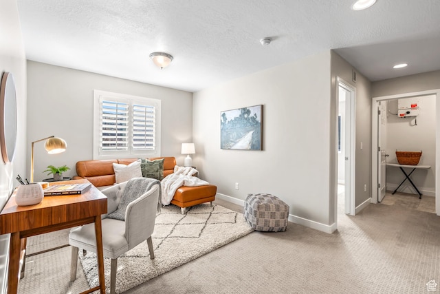 carpeted office space with baseboards and a textured ceiling