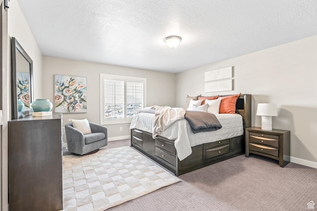bedroom with baseboards, light carpet, and a textured ceiling