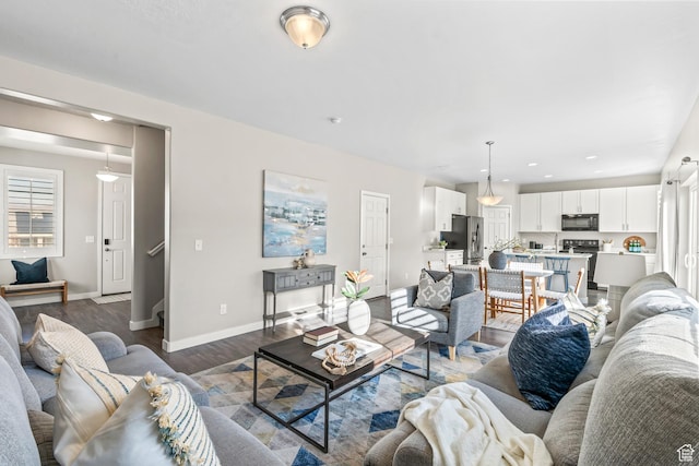 living area with recessed lighting, wood finished floors, and baseboards