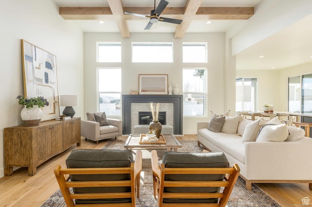 7277 W Hall Crossing Dr S, Herriman, UT 84096 - living area with a ceiling fan, beamed ceiling, light wood-style flooring, coffered ceiling, and a glass covered fireplace