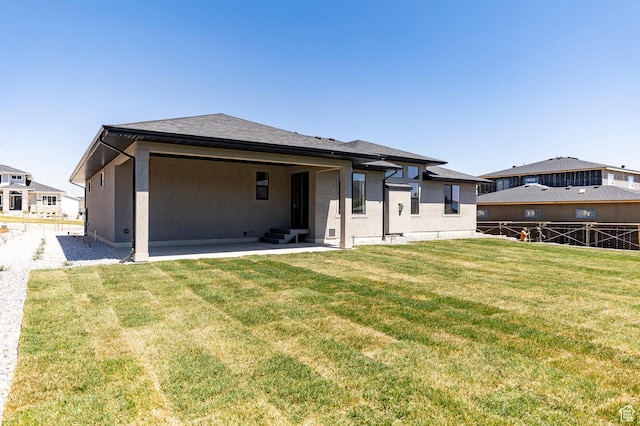 7277 W Hall Crossing Dr S, Herriman, UT 84096 - back of property with a yard, entry steps, a patio area, fence, and stucco siding