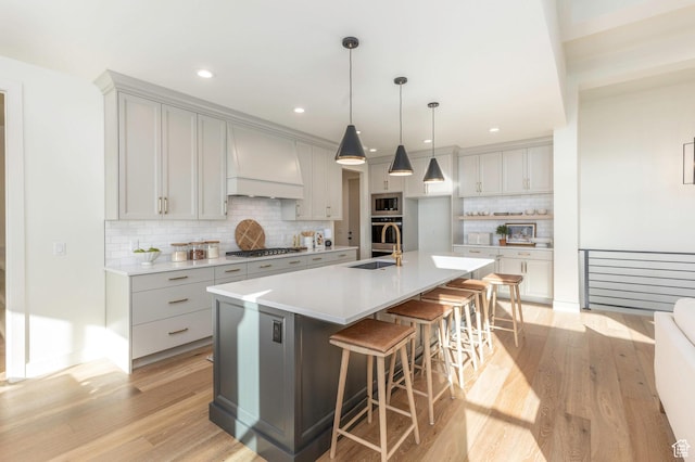 7277 W Hall Crossing Dr S, Herriman, UT 84096 - kitchen with wall chimney exhaust hood, a kitchen breakfast bar, tasteful backsplash, light wood-type flooring, and stainless steel appliances