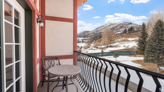 snow covered back of property featuring a mountain view