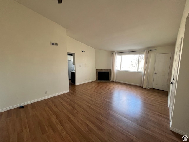 989 E Creekhill Ln S Unit 31, Midvale, UT 84047 - unfurnished living room featuring lofted ceiling, wood-type flooring, and a brick fireplace