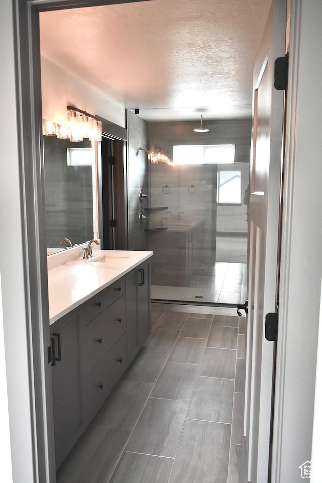 bathroom featuring vanity, a textured ceiling, and walk in shower