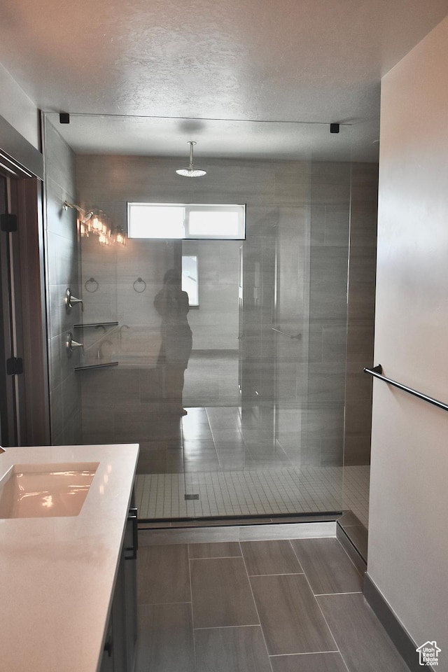 bathroom with vanity and a tile shower