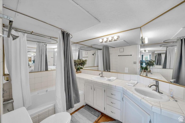 full bathroom with toilet, shower / tub combo, vanity, and a textured ceiling
