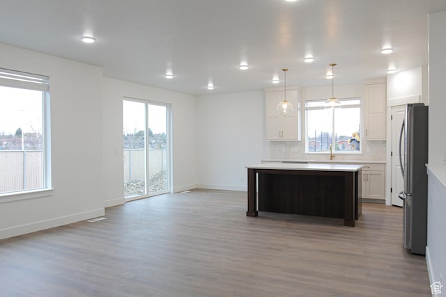 1336 E 1220 N, Logan, UT 84321 - kitchen featuring a center island, wood finished floors, freestanding refrigerator, light countertops, and decorative backsplash