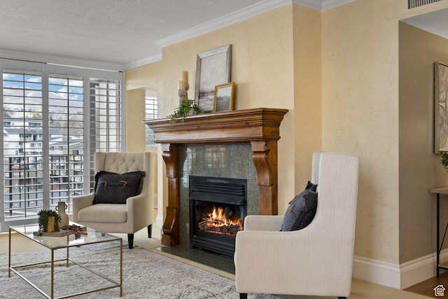 living area with a fireplace, a textured ceiling, and crown molding