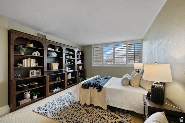 carpeted bedroom featuring a textured ceiling
