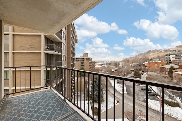 snow covered back of property with a mountain view