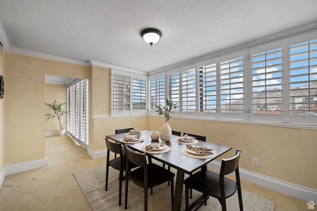 dining space with ornamental molding, light colored carpet, and a textured ceiling