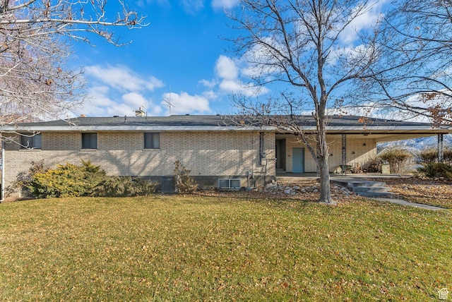 back of property with a carport and a lawn